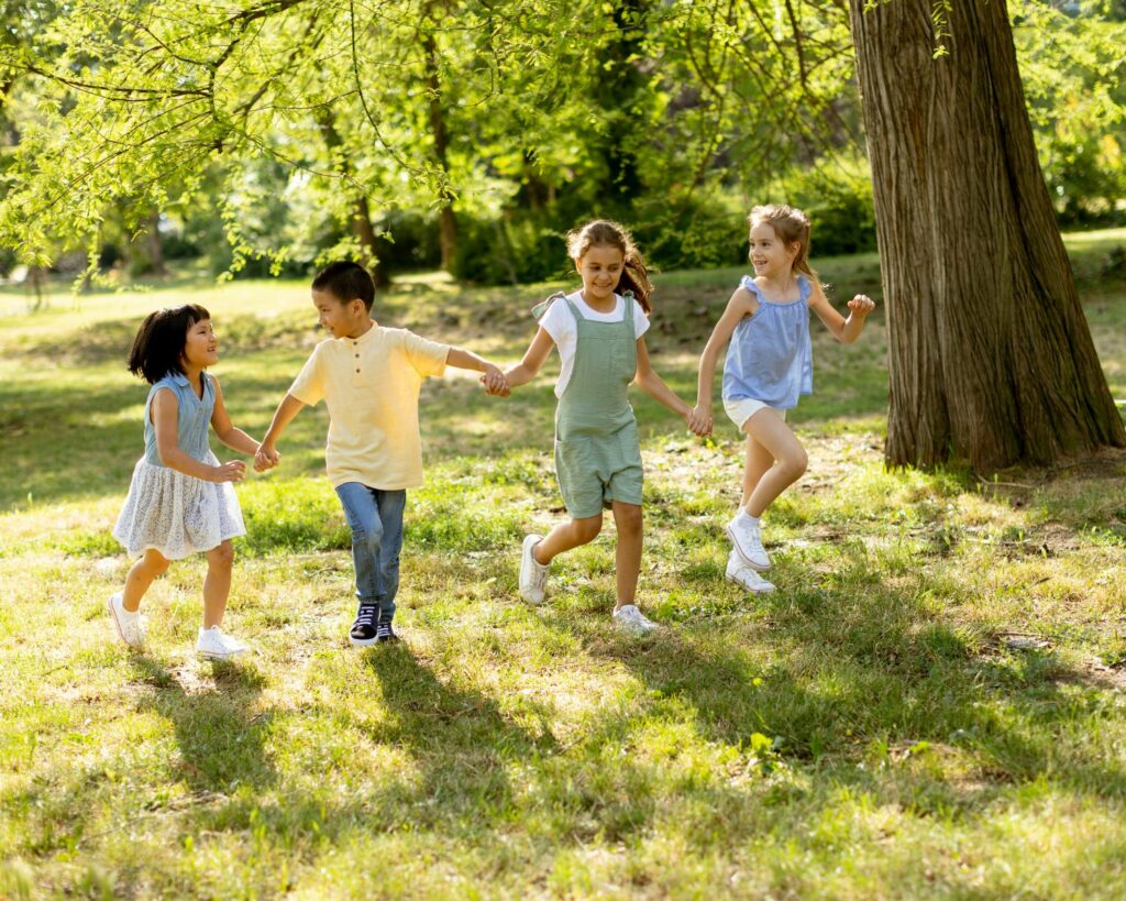 Quatre enfants qui courent et jouent ensembles